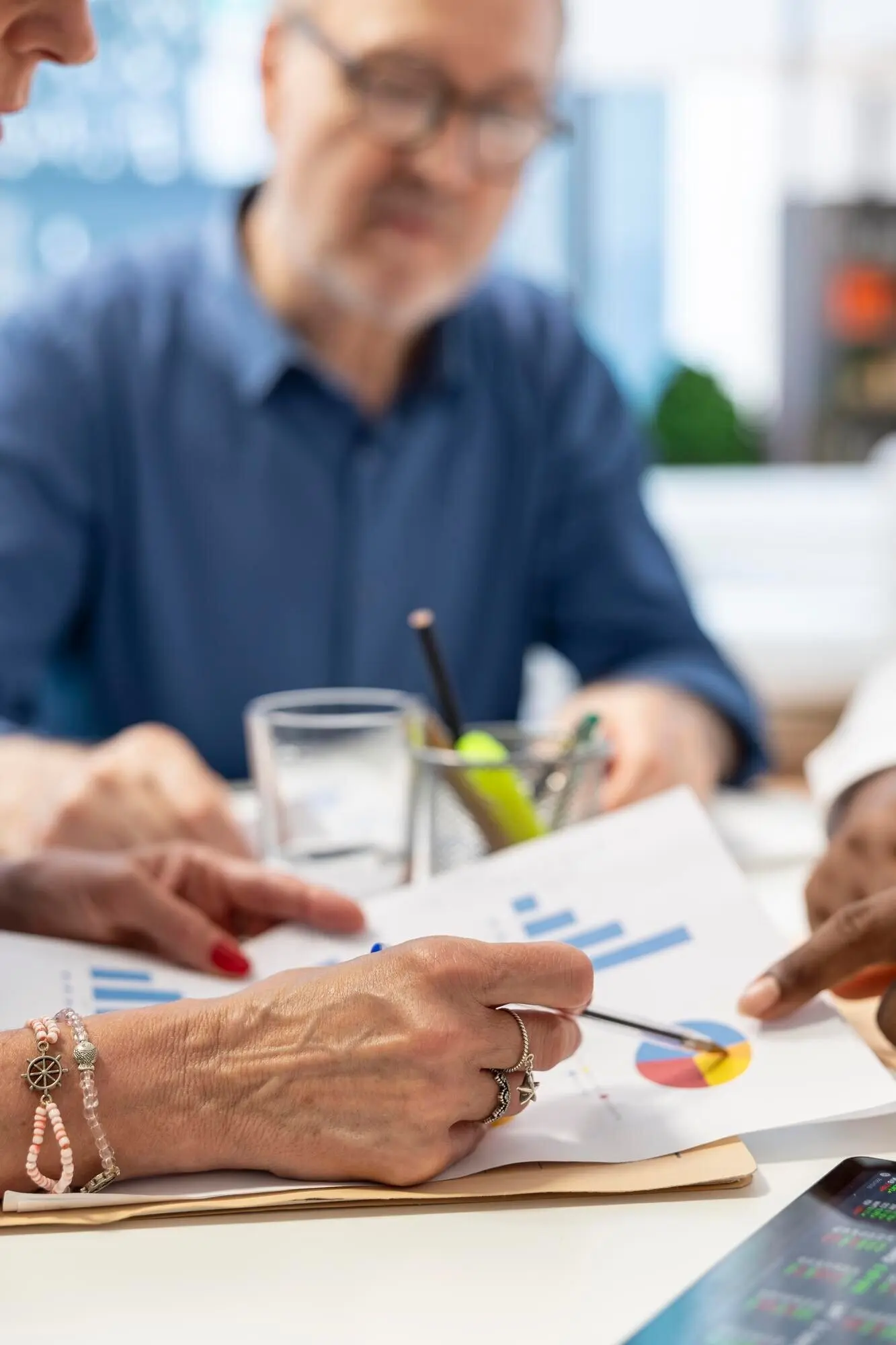 Пожилые клиенты в современном офисе встречаются с финансовым экспертом.